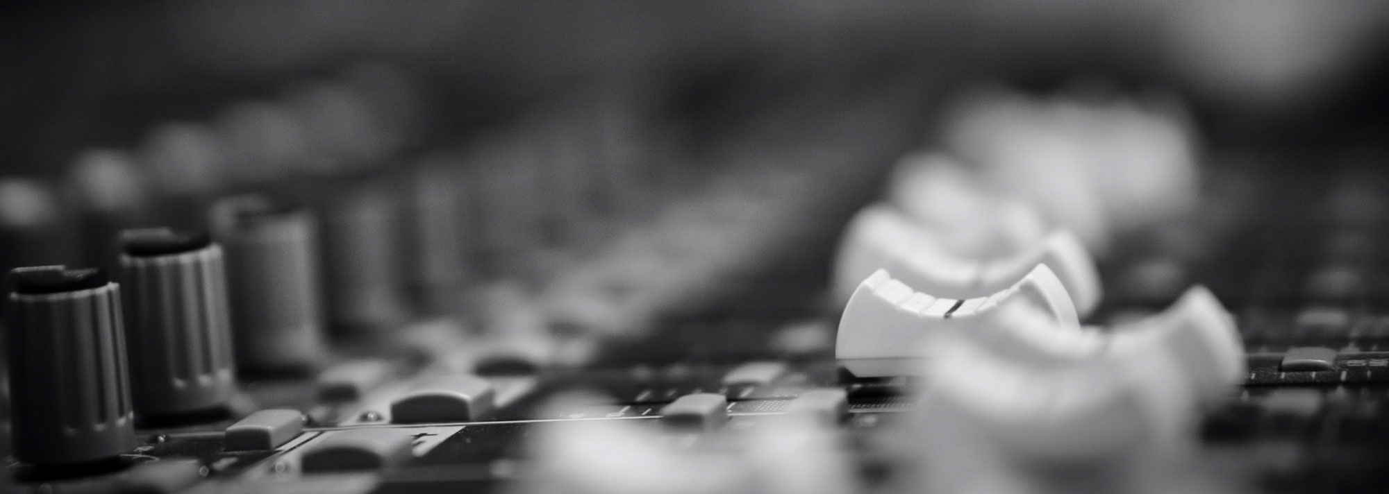 Black and white photo of a large format console with faders