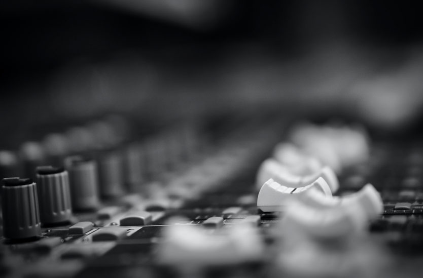 Black and white photo of a large format console with faders
