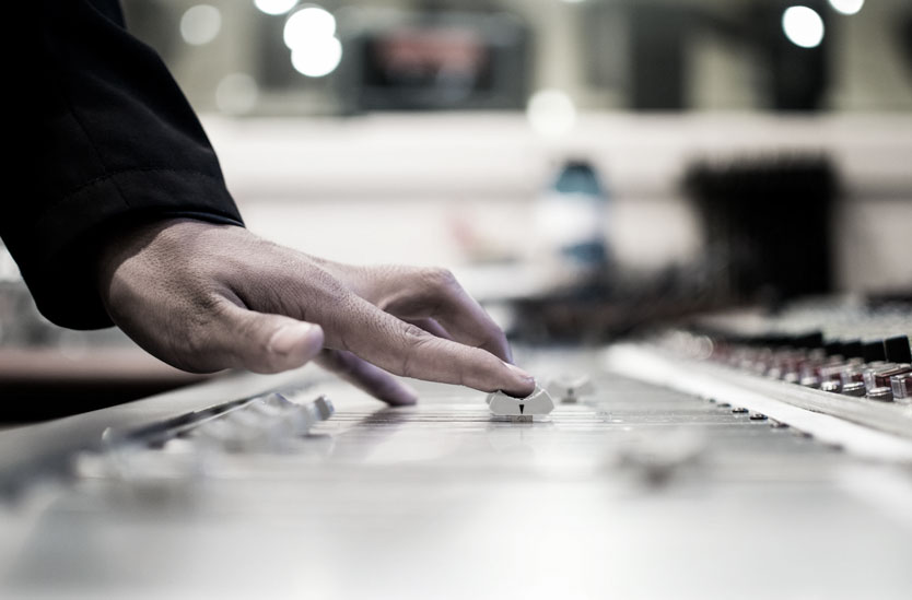 Audio engineer's finders moving a fader on a large format recording console